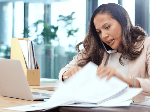 Freight agent looking through documents while on the phone; financial planning for freight agents; Sureway