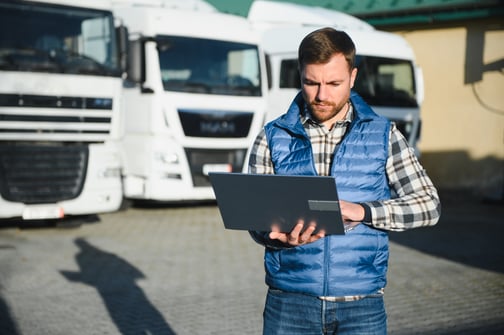 logistics-manager-works-on-laptop-near-trucks-2026-01-08-08-08-10-utc logistics agents, brokerage platform, commission splits, Sureway