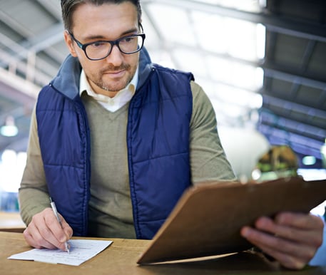 man-inspecting-inventory-and-taking-notes-at-work; financial planning for freight agents; Sureway